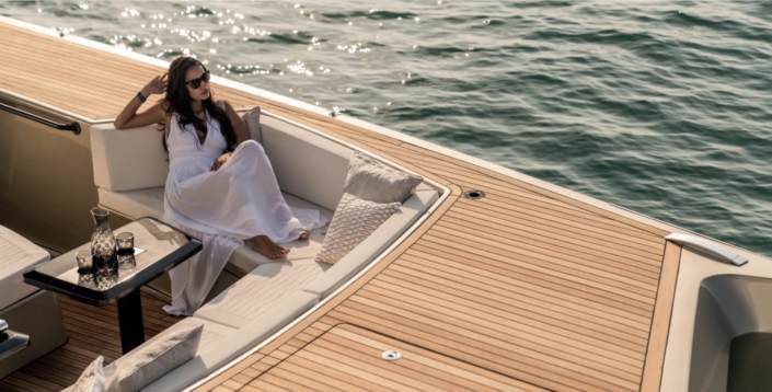 woman yachting with etiquette on calm seas at sunset- yacht etiquette tips